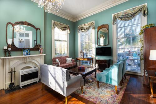 ein Wohnzimmer mit grünen Wänden und einem Kronleuchter in der Unterkunft The Mansion on Royal in New Orleans