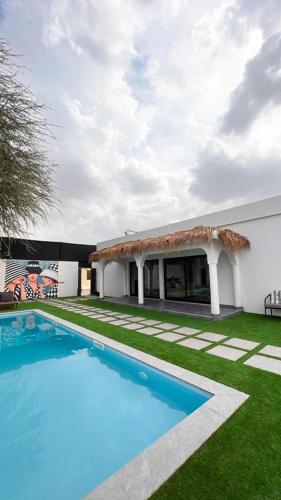 una piscina nel cortile di una casa di Two Palm - Villa a Ras al Khaimah