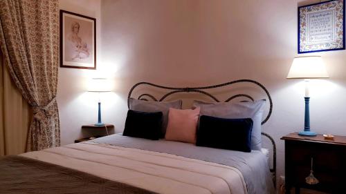 a bedroom with a bed with pillows and two lamps at Ginevra Casa Vacanze in Panzano