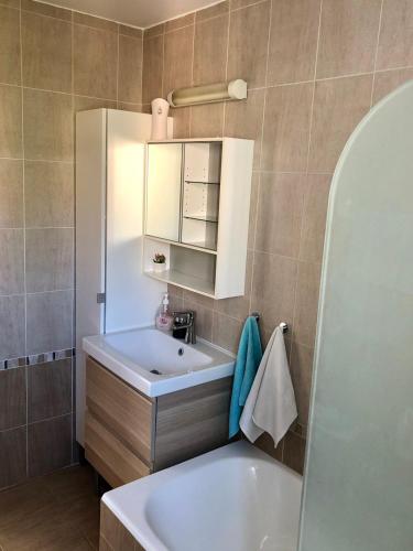 a bathroom with a white sink and a tub at Estia Luxury Maisonette in Paphos
