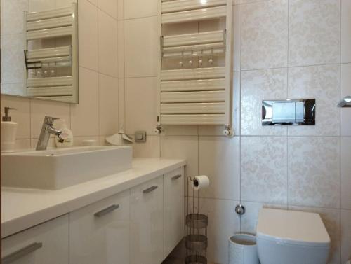 a white bathroom with a toilet and a sink at Ataşehir Lüks Rezidans in Istanbul