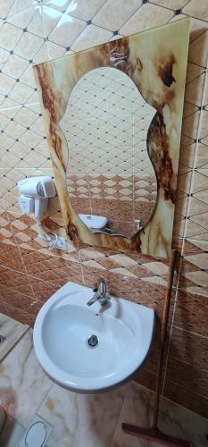 a bathroom with a sink and a mirror at Nabateans Home Hotel in Wadi Musa