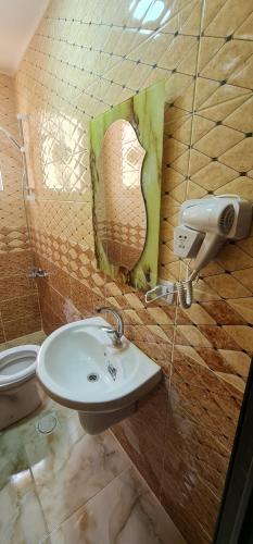 a bathroom with a sink and a painting on the wall at Nabateans Home Hotel in Wadi Musa