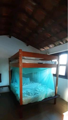 a bunk bed with blue sheets in a room at Casinha do Cauipe in Caucaia