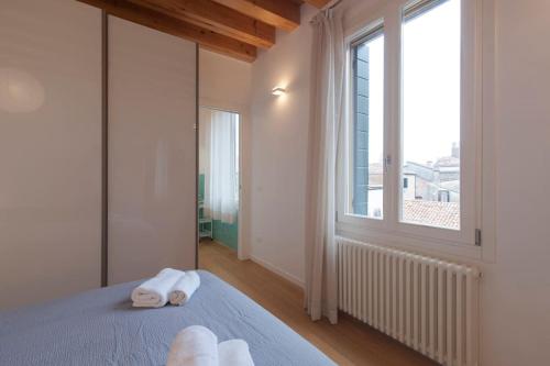 um quarto com duas toalhas numa cama com uma janela em Bauhaus Venice Apartment em Veneza