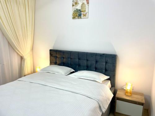 1 dormitorio con 1 cama blanca grande y 2 lámparas en TAJ en Ipoteşti