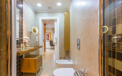 een badkamer met een wastafel, een toilet en een bad bij Casa Segaria in Denia
