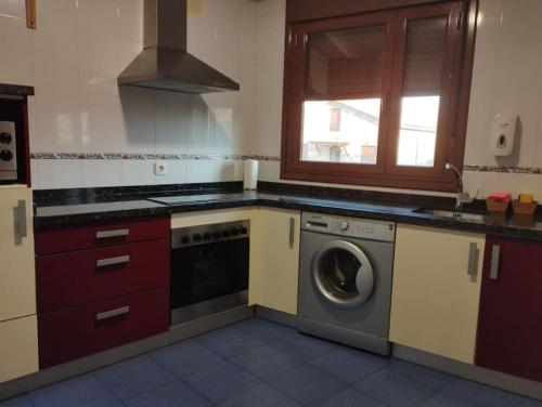 a kitchen with a washing machine and a window at Precioso piso con ducha hidromasaje VUT-LE-726 in Astorga