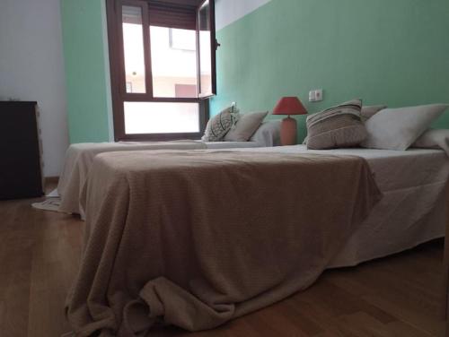 a bedroom with a large bed with a blanket on it at Precioso piso con ducha hidromasaje VUT-LE-726 in Astorga