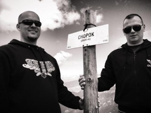 two men are standing next to a street sign at Domceky Holiday in Liptovský Trnovec