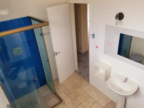 een badkamer met een douche, een toilet en een wastafel bij Apto Praia Gonzaga - melhor localização in Santos