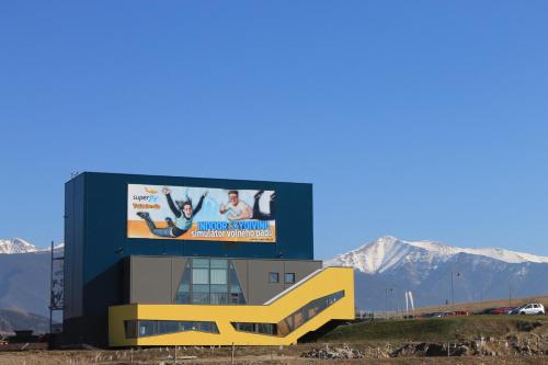 a building with a billboard on it with mountains in the background at Domceky Holiday in Liptovský Trnovec