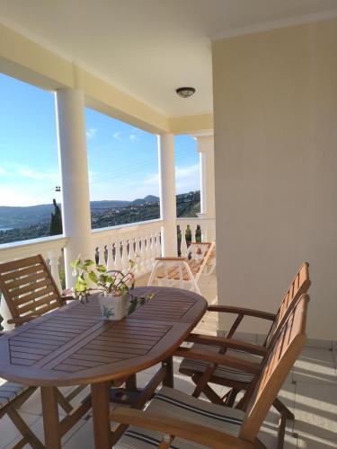 un tavolo in legno con sedie e un balcone con vista. di Villa Panorama a Lourdata