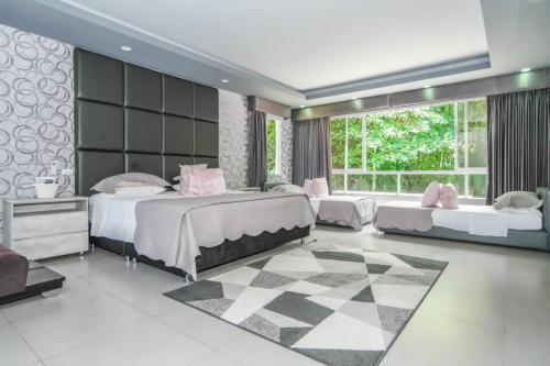 a bedroom with two beds and a large window at CASA LUZ Hospedaje, Pereira , Cerritos in Pereira