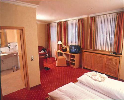 Bad Rippoldsau-SchapbachにあるHotel Restaurant Ochsenwirtshofのベッドとバスルーム付きのホテルルームです。