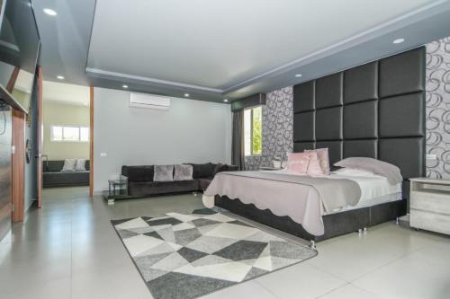 a bedroom with a large bed and a couch at CASA LUZ Hospedaje, Pereira , Cerritos in Pereira