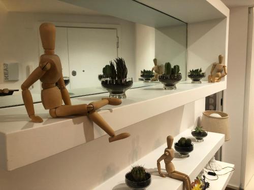 a room with a wooden mannequin sitting on a shelf with plants at Lungotevere Bed&Bike in Rome