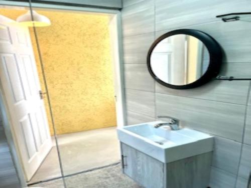 La salle de bains est pourvue d'un lavabo et d'un miroir. dans l'établissement Emba Guest lodge No loadshedding, à eMbalenhle