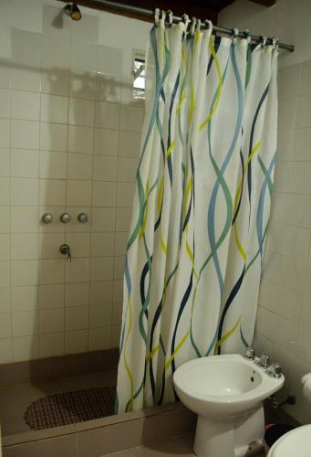 a bathroom with a shower curtain and a toilet at Espacio Infinito in Capilla del Monte