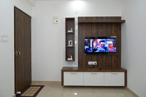 a living room with a flat screen tv on a entertainment center at DivBnK homes Bangalore in Bangalore