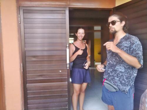 a man and a woman standing in front of a door at Mocca Guest House in Banyuwangi