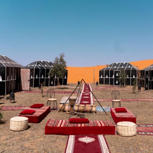 um parque infantil com colchões vermelhos e um baloiço em djou luxury desert camp em Merzouga