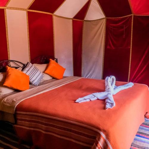 um quarto com uma cama numa tenda em djou luxury desert camp em Merzouga