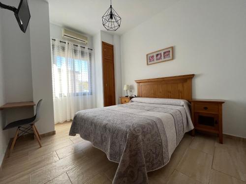 1 dormitorio con 1 cama, 1 silla y 1 ventana en Hostal Parador de los Llanos en Torreorgaz