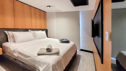 a bedroom with a bed with a hat and a television at Çimentepe Residence Deluxe in Bodrum City