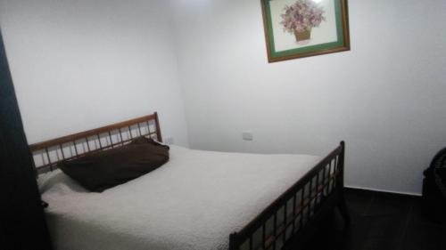 a bed in a bedroom with a picture on the wall at Villa Elisa,La Plata Apart II in Villa Elisa
