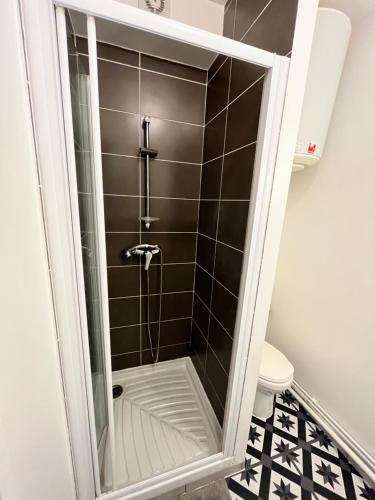 une douche avec une porte vitrée dans une salle de bain dans l'établissement Le 136 B, à Grenoble