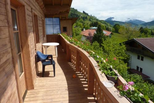a wooden balcony with a chair on a house at Haus Moosanger in Oberau