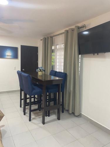 a dining room with a wooden table and blue chairs at Departamento gaviota in Cozumel