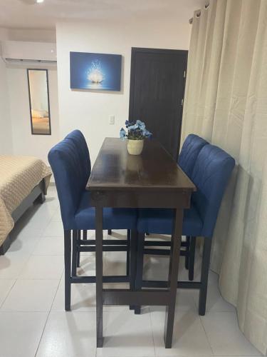 a dining room table with blue chairs and a table at Departamento gaviota in Cozumel