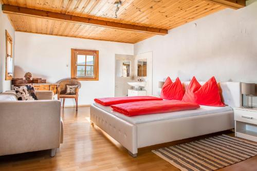 a bedroom with a large bed with red pillows at Bauernhof Lehengut in Pfarrwerfen