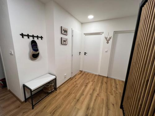 a hallway with white walls and wooden floors and a bench at Apartmán Víšek in Jáchymov