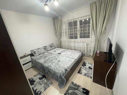 a small bedroom with a bed and a television at Apartament 2 camere in Petroşani