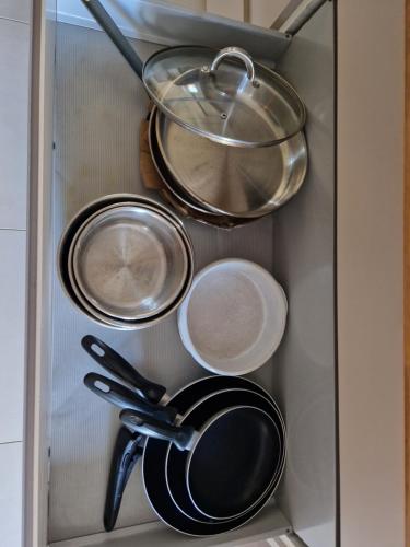 a drawer with pots and pans in a cabinet at MAGNIFIQUE VILLA LUXE COSY POPPIES HOLIDAY - Normandie Beach Racing, Flipper, Baby-foot, SPA, Jardin Méditerranéen, Plage Riva Bella à 300m, Mer à Pied, Tout Confort, Idéale Familles & Groupes, EVJ à Ouistreham, Proche Cabourg, Week-end & Courts Séjours ! in Ouistreham