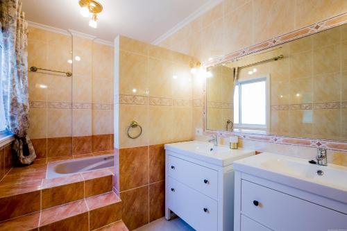 W łazience znajdują się 2 umywalki, prysznic i lustro. w obiekcie True Canarian 6 bedrooms villa with hot tub w mieście Callao Salvaje