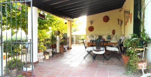 a patio with a table and chairs and plants at DONNA CATERINA HOUSE in Pietraperzia