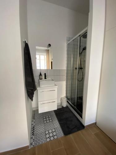 une salle de bain blanche avec une douche et un lavabo dans l'établissement 2 pièces / neuf - Ajaccio centre - Place Miot / Albert 1er, à Ajaccio