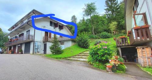 Una casa con una cinta azul a un lado. en Il Belvedere, en Nevegal