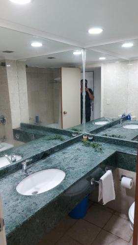 a man taking a picture of a bathroom sink at מגדל C1 in Netanya