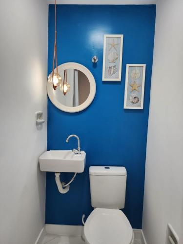 a blue bathroom with a toilet and a sink at Quadra do mar de Jardim Camburi in Vitória