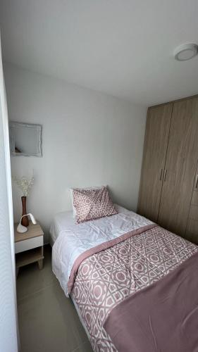 1 dormitorio con 1 cama y armario de madera en APTO Sur VALLE DEL LILI, en Cali