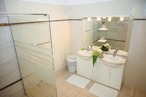 Baño blanco con lavabo y espejo en Villa D ENNRY, en Pointe-Noire