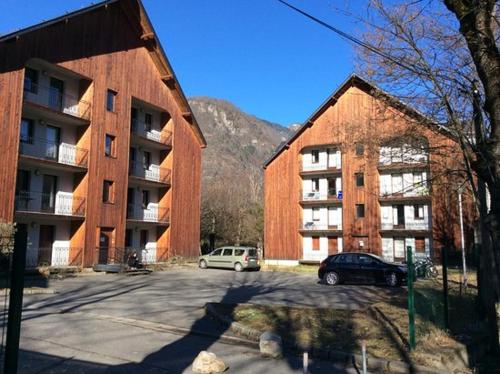 a parking lot in front of two large buildings at T3 cosy au Jardin du Ramel in Luchon