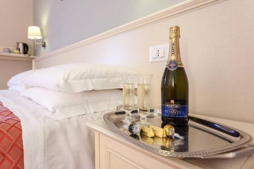 a bottle of wine on a tray next to a bed at Ottaviano Guest House in Rome
