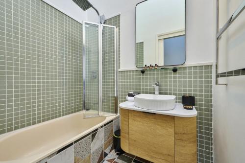 a bathroom with a sink and a bath tub at Carlton Dream: Leafy 2bed 2bath Lygon Str Townhouse in Melbourne