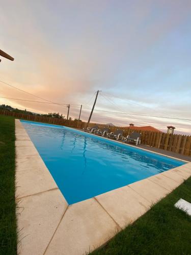 a swimming pool with blue water in a yard at Refúgio do Vale in Celorico de Basto